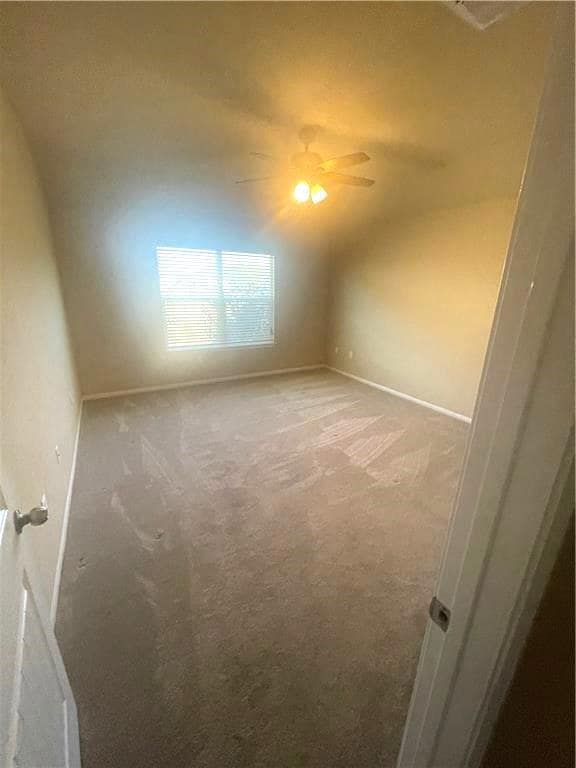 Empty room featuring vaulted ceiling, light carpe