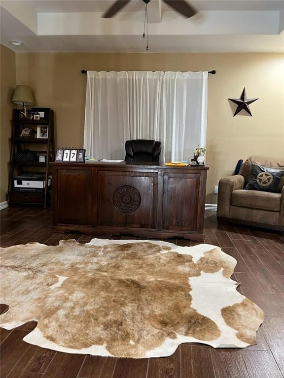 Office space featuring dark wood finished floors, a ceiling fan, and baseboards