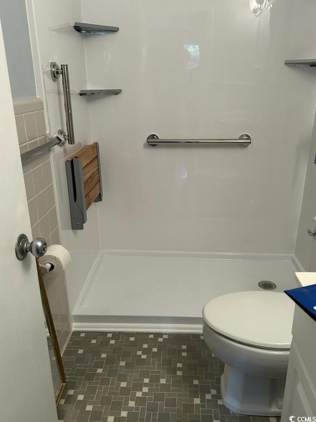 Bathroom with vanity, a shower, and toilet