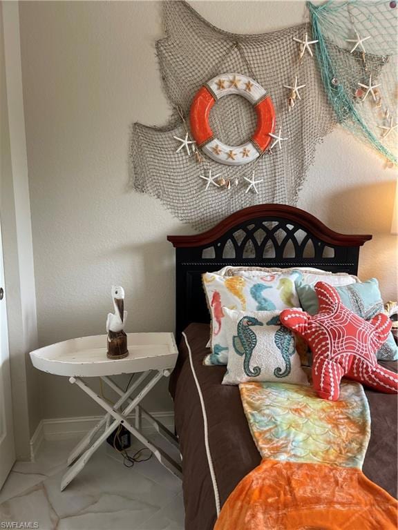 Bedroom with a textured wall and baseboards