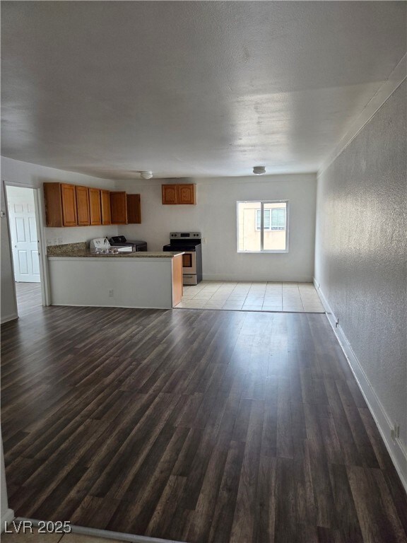 Unfurnished living room featuring wood finished fl