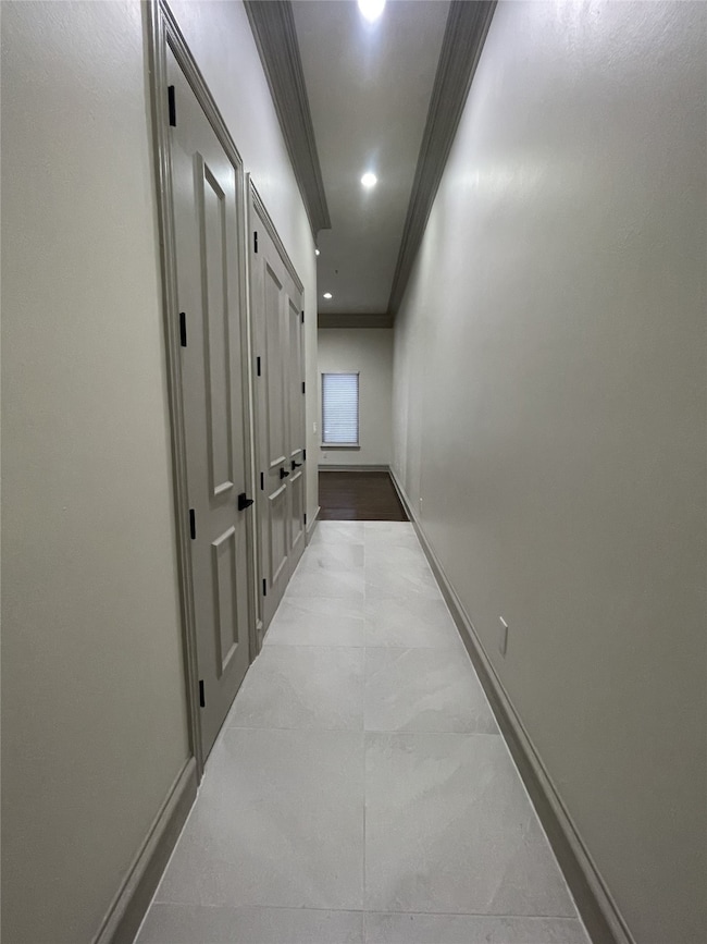 Hallway with ornamental molding and recessed lighting