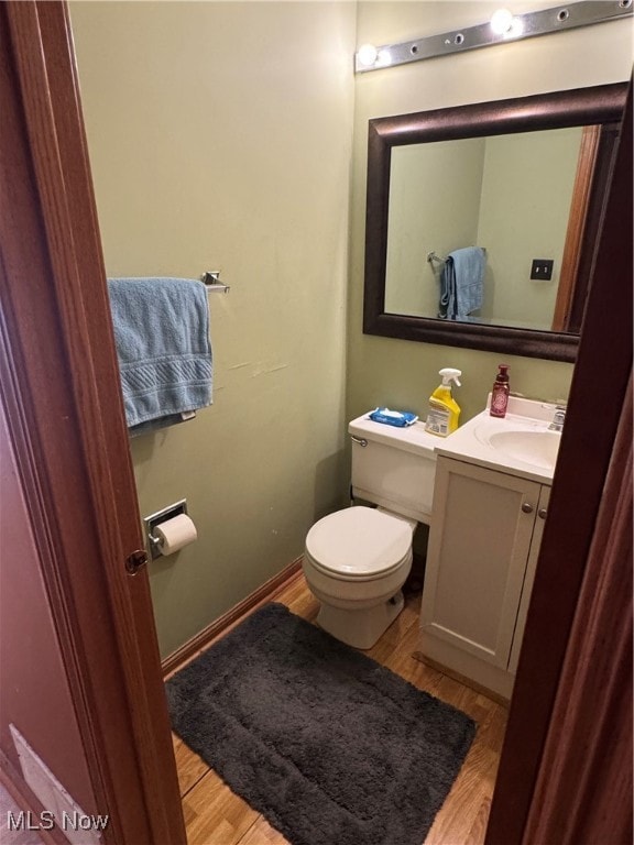 Half bathroom with light wood-style floors and vanity
