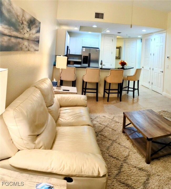 Living area with light tile patterned floors and recessed lighting