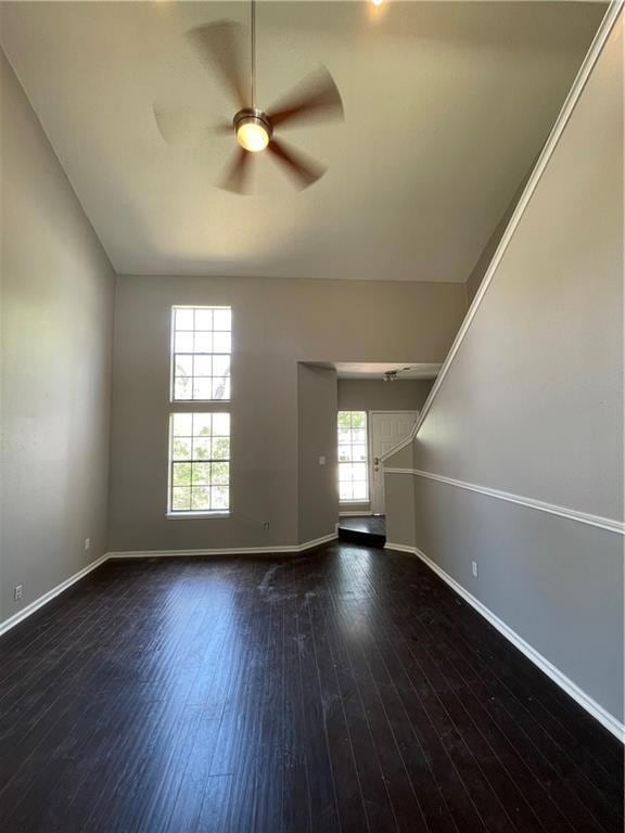 Unfurnished room featuring a ceiling fan and dark wood-type flooring