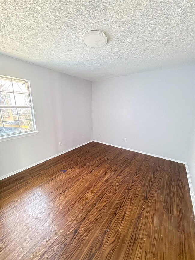 Empty room featuring dark wood-type flooring, a t
