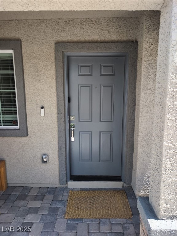 Property entrance featuring stucco siding