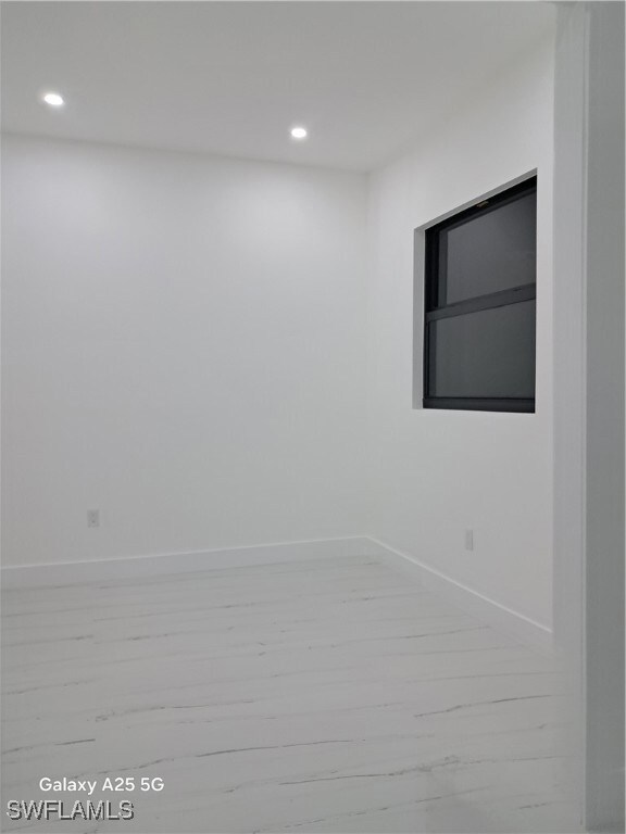 Spare room with recessed lighting, baseboards, and