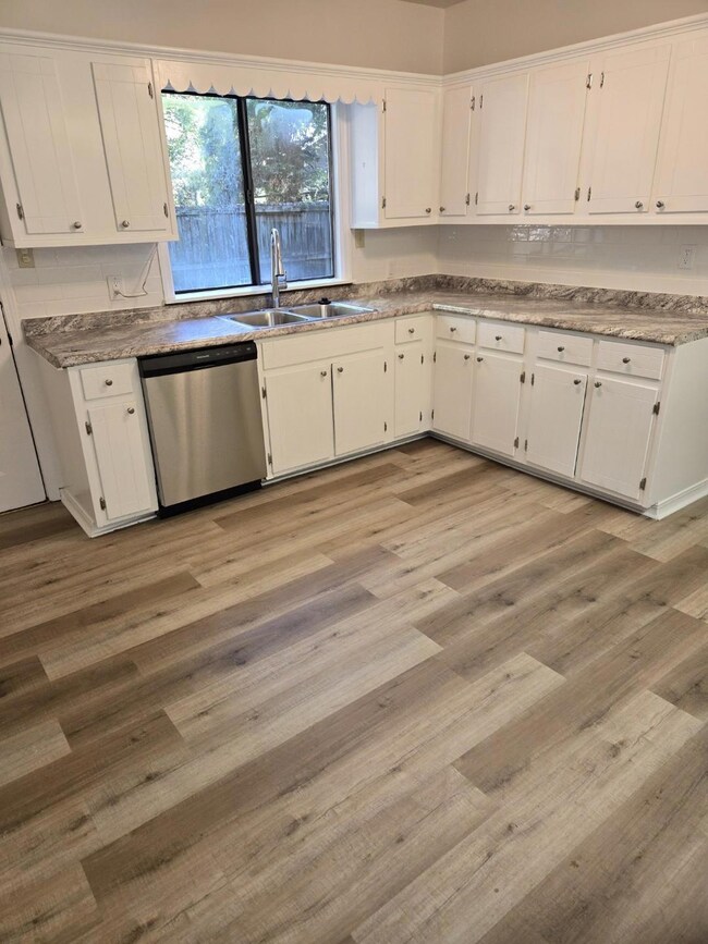 Large kitchen area with new flooring, lots of kitc