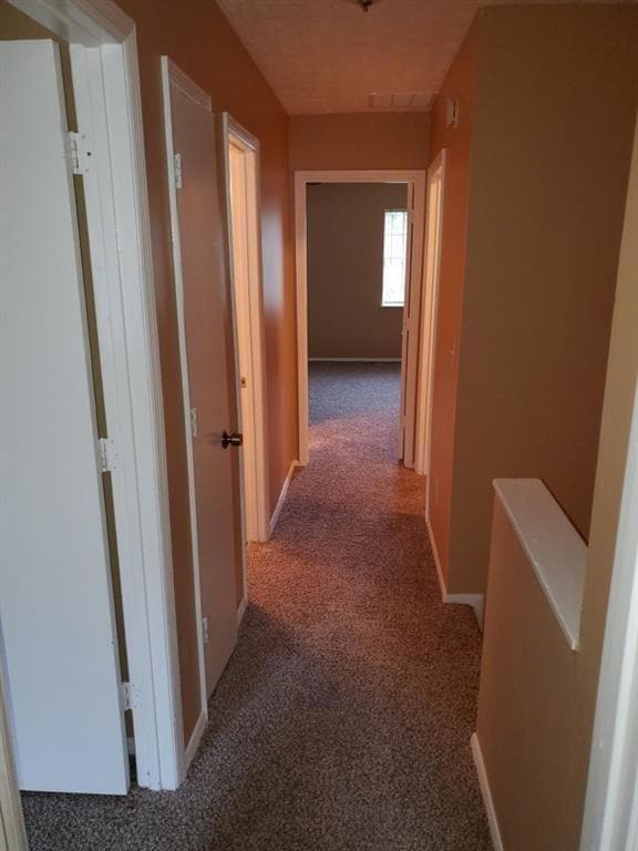 Hall featuring carpet and baseboards