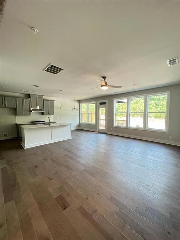 Unfurnished living room featuring baseboards, a he