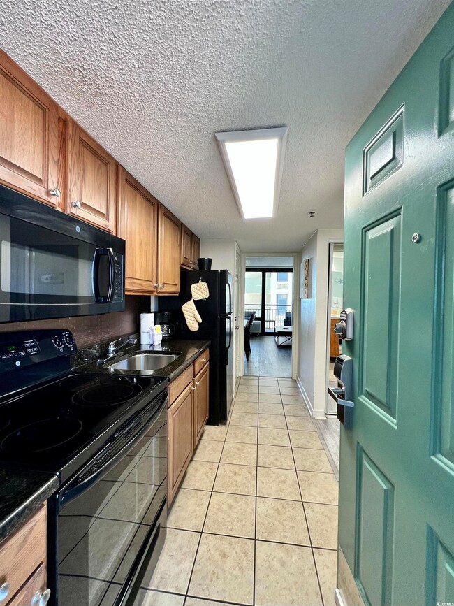 Kitchen with brown cabinets, light tile patterned 