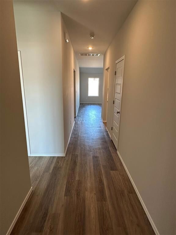 Hallway with dark wood finished floors, visible ve