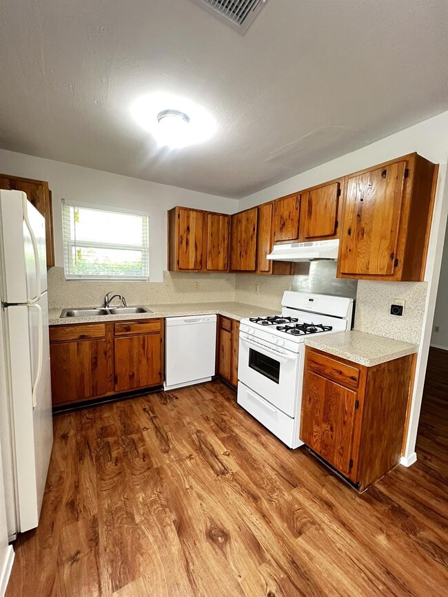 Kitchen with white appliances, a sink, under cabi