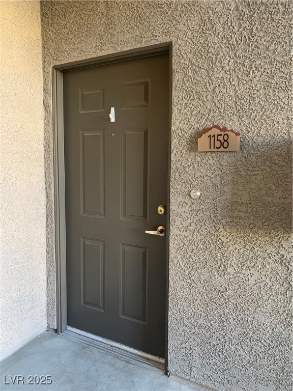 Doorway to property with stucco siding