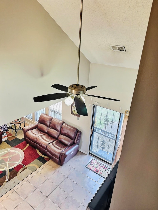 Living room with visible vents, high vaulted ceili