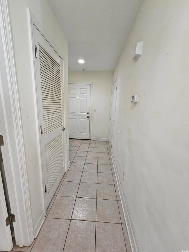 Corridor with light tile patterned floors and recessed lighting