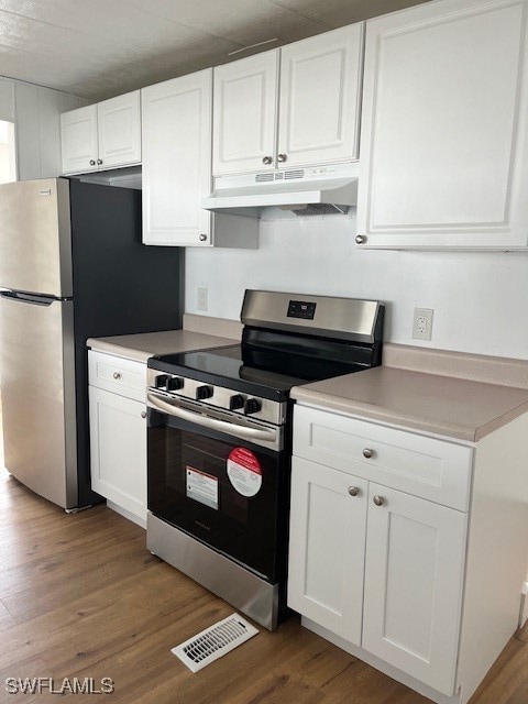 Kitchen featuring white cabinetry, hardwood / wood