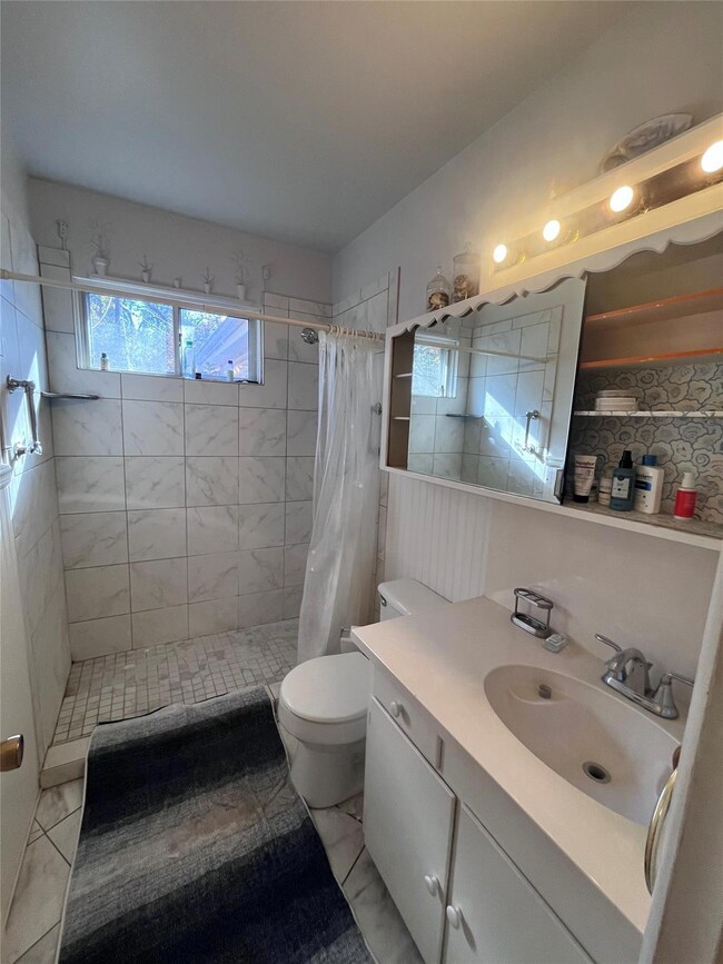Bathroom featuring backsplash, toilet, vanity, and