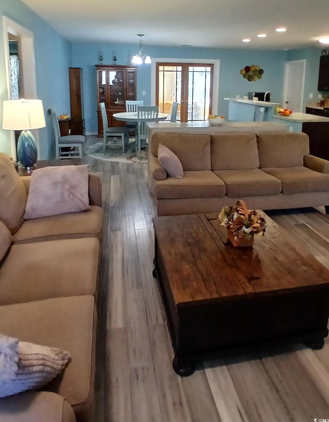 Living area with light wood finished floors and a chandelier