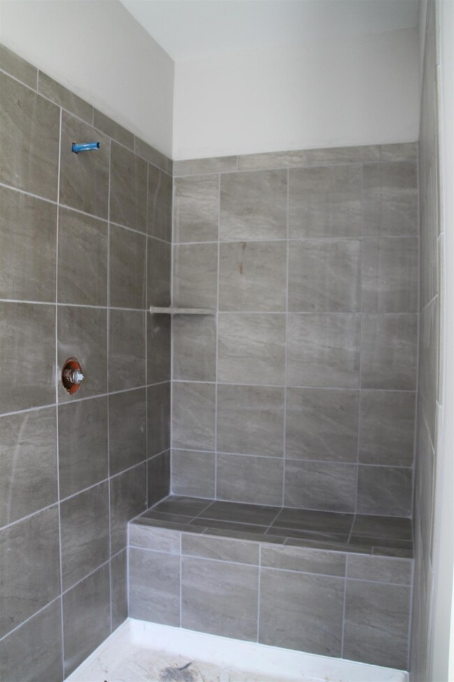 Master shower is spacious and has a nice tile seat.  Glass door not yet installed.  Similar home.