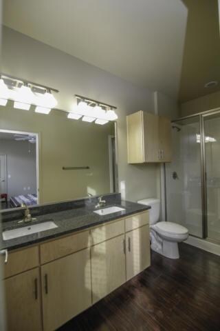 Full bath featuring a shower stall, double vanity