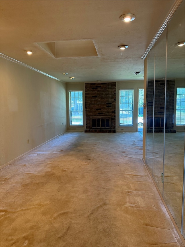 Unfurnished living room with a fireplace, plenty of natural light, carpet flooring, ornamental molding, and recessed lighting