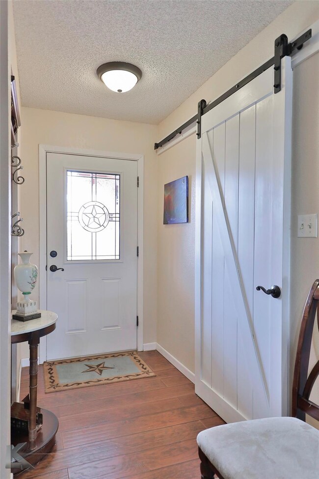 Entrance foyer with a textured ceiling, a barn doo