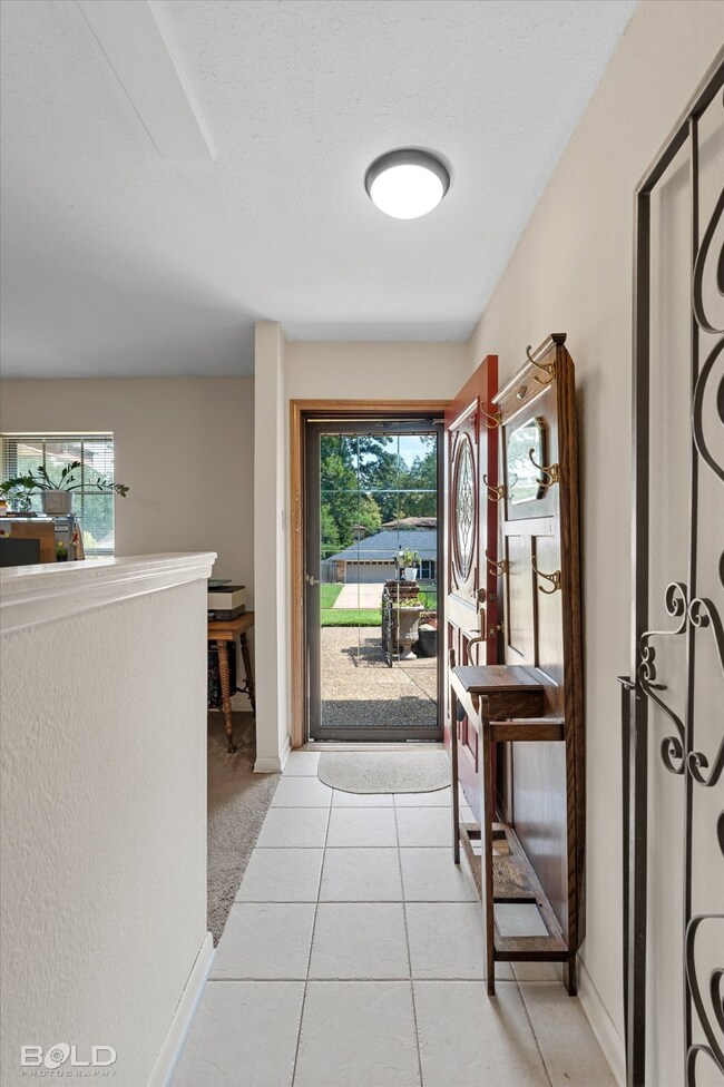 Doorway featuring tile patterned floors, healthy amount of natural light, and carpet floors