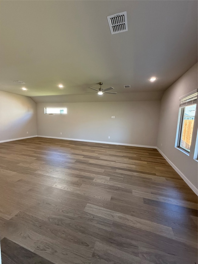 Empty room featuring dark wood-style flooring, ceiling fan, and recessed lighting