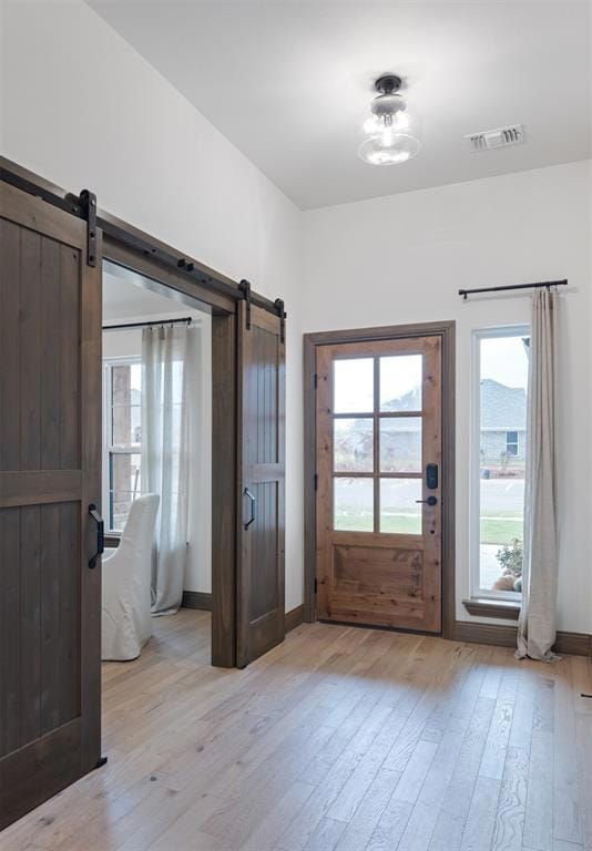 Entrance foyer featuring baseboards, a barn door, 