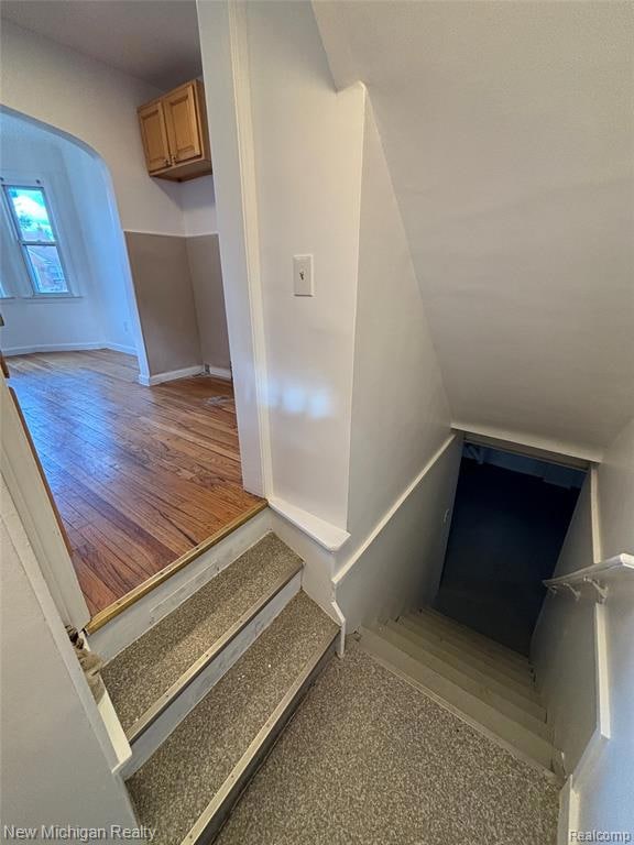 Stairs featuring arched walkways and baseboards