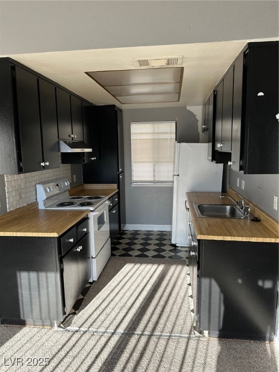 Kitchen with dark cabinetry, stove, and tile patte