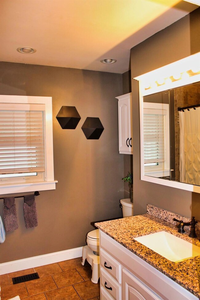 Full bath with tub/shower, white vanity and loads 