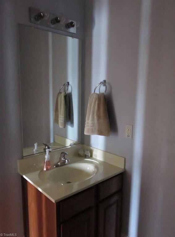 Cherry vanity half bath is off the main hall.