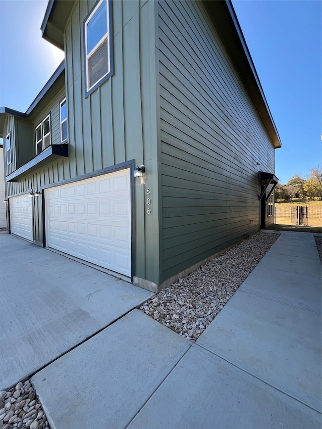 View of home's exterior featuring a garage, board and batten siding, and concrete driveway