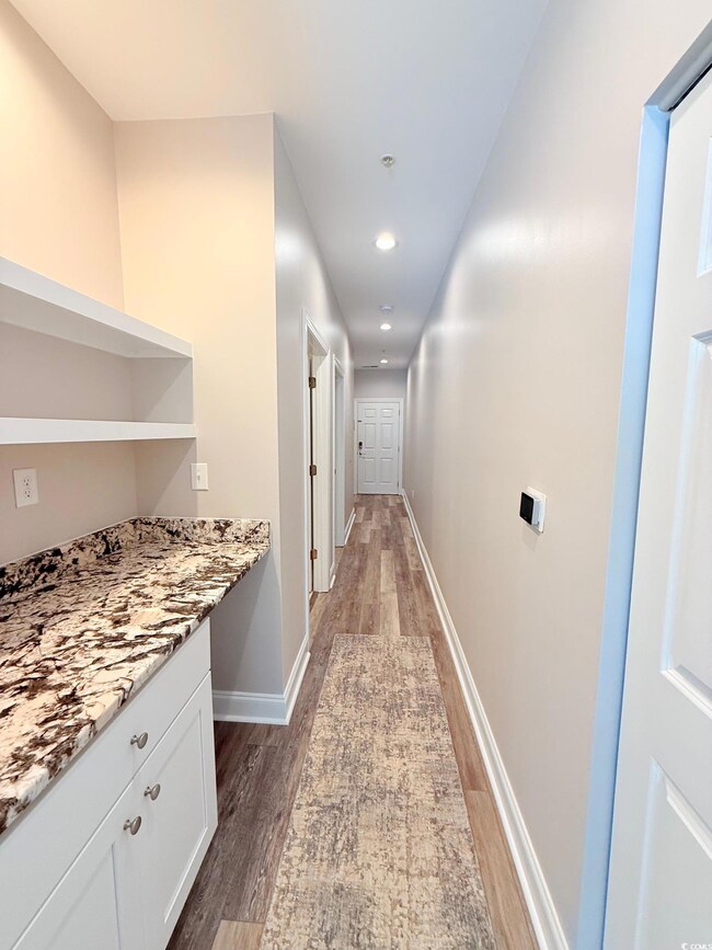 Hallway with baseboards, wood finished floors, and recessed lighting