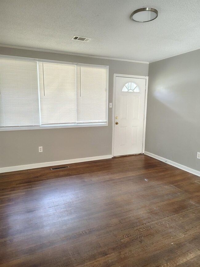Foyer with a textured ceiling and dark hardwood / 