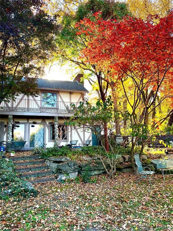 View of side of property featuring a balcony and stucco siding
