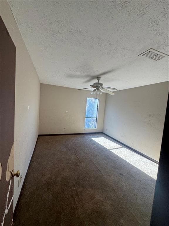 Carpeted spare room with ceiling fan and a texture