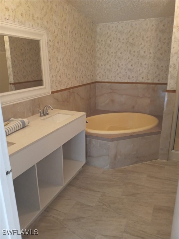 Full bathroom featuring wallpapered walls, tile wa