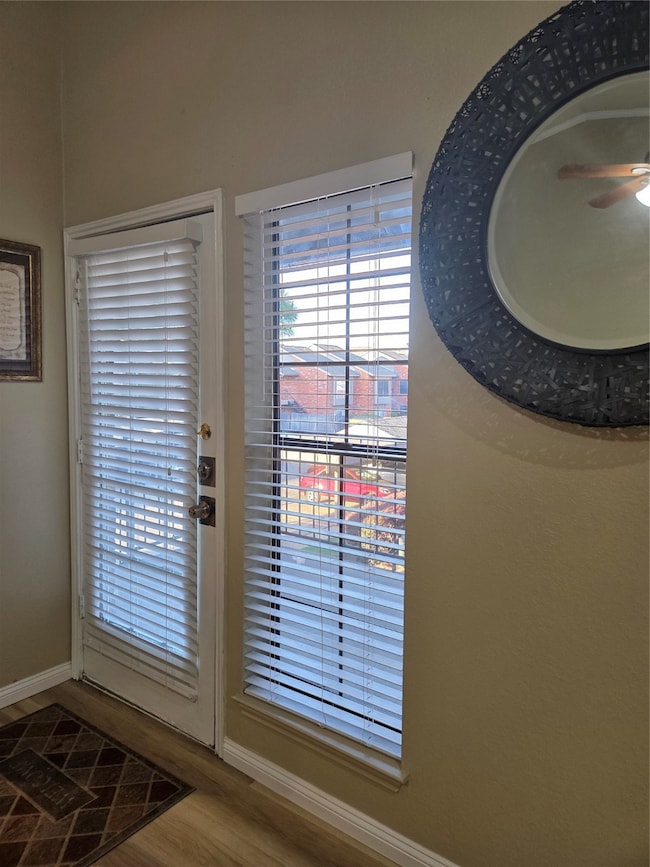 Room details featuring baseboards, wood finished floors, and a ceiling fan