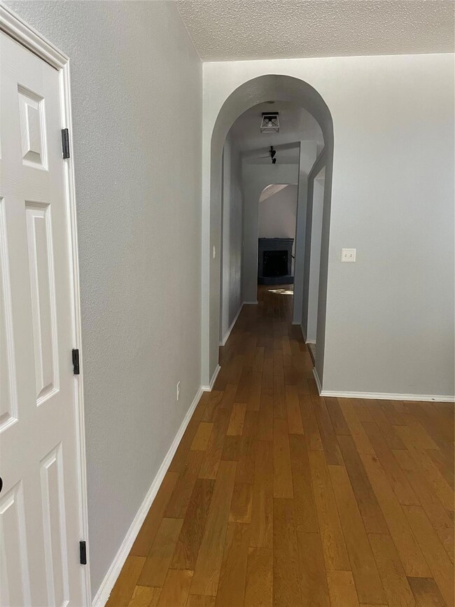 Corridor featuring wood-type flooring and a textured ceiling