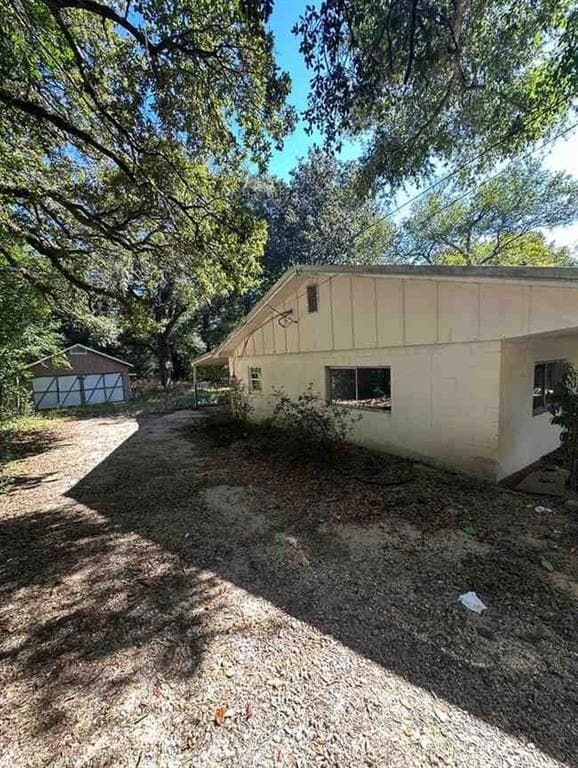 View of home's exterior featuring concrete block siding, an outdoor structure, and board and batten siding