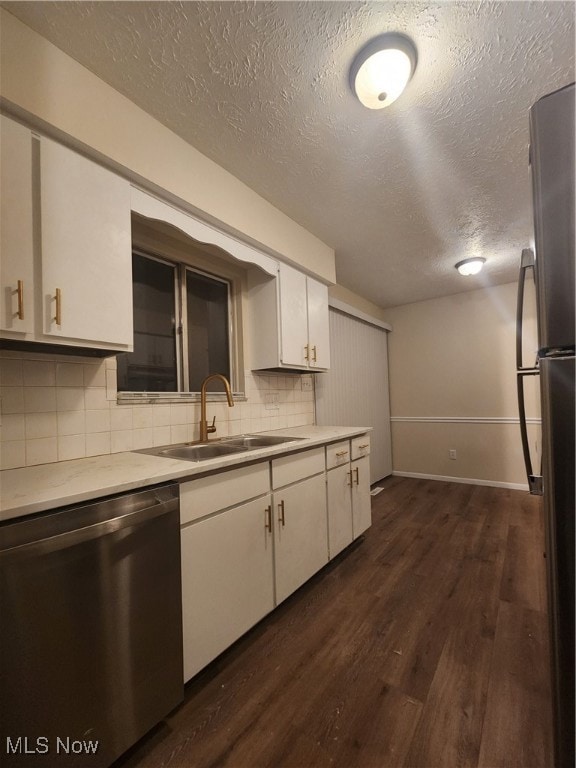 Kitchen featuring light countertops, dishwasher, a textured ceiling, dark wood finished floors, and decorative backsplash