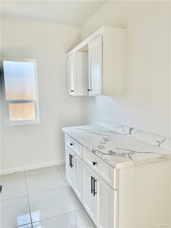 Clothes washing area with light tile flooring