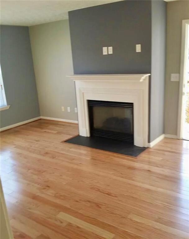 Room details with baseboards, a glass covered fire