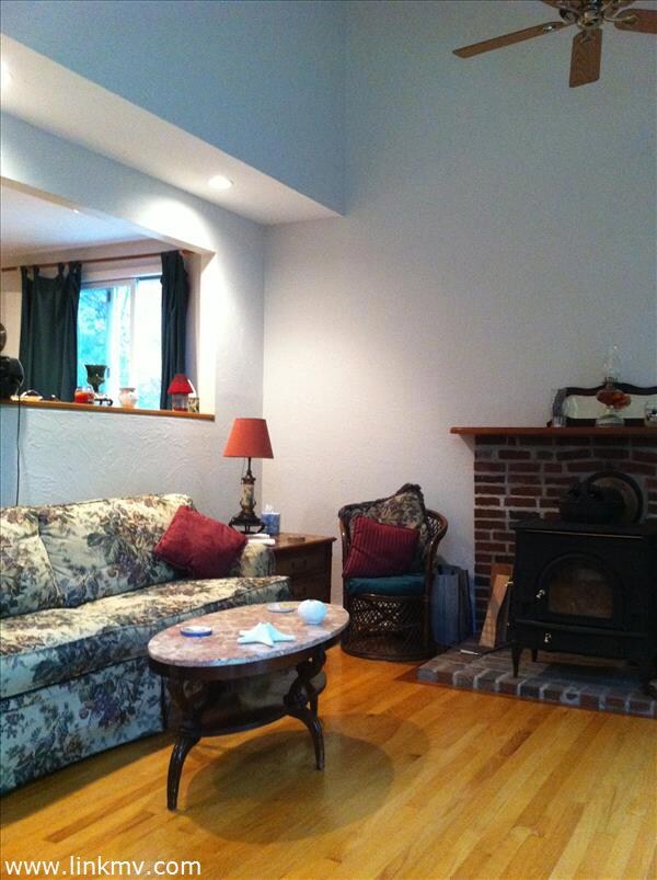 large living room with brick hearth and woodstove