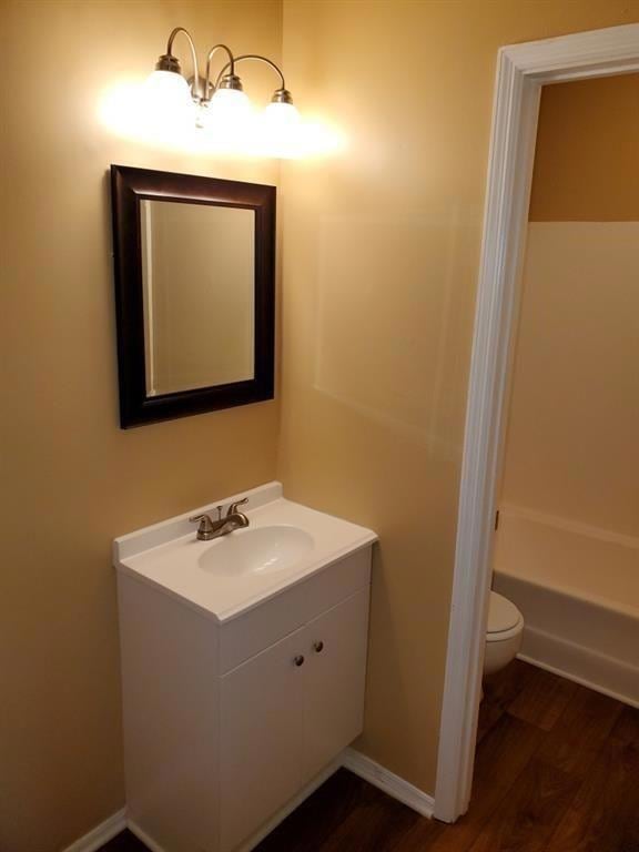 Full bath featuring vanity, wood finished floors, and a tub