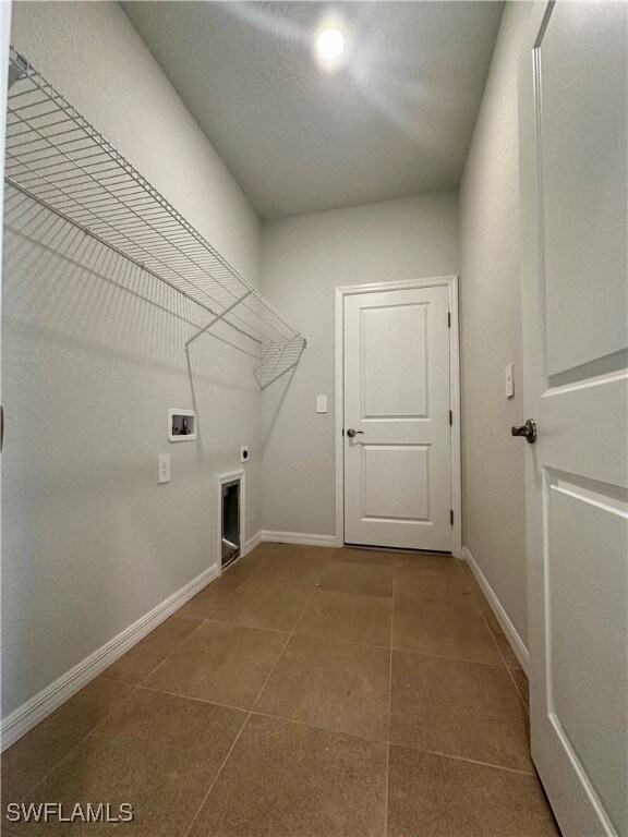Clothes washing area featuring electric dryer hook